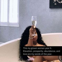 a woman sitting in a bathtub holding a wine glass with the caption'this is my grown woman year fr elevation prosperity, abundance, and love are my words of the year