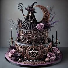 an elaborately decorated cake with candles and flowers on it's side, topped by a witch figurine