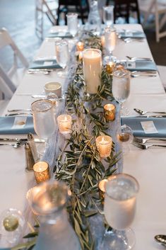 a long table is set with candles and place settings for an elegant dinner or party