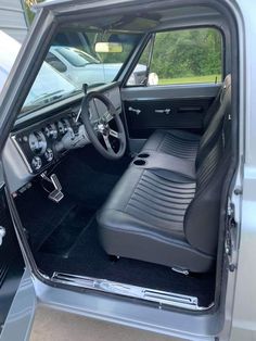 the interior of a truck with its door open and steering wheel in it's center