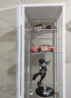 a display case with two cars on top of it and one in the bottom tier