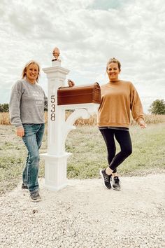 two women standing in front of a mailbox