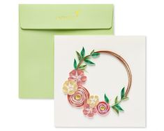 a greeting card with flowers and leaves on it, next to an envelope that says happy birthday