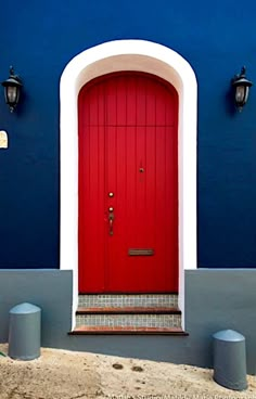 a red door is on the side of a blue building