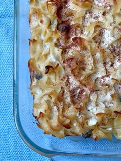 a casserole dish with pasta and meat in it on a blue table cloth