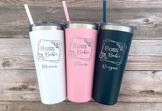 three personalized tumblers with straws in them sitting on a wooden table next to each other