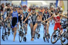 a group of people riding bikes on top of a blue floor next to each other