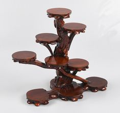 a wooden tree with four stools on it's sides and one sitting in the middle