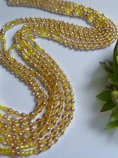 Double Strand Waist Bead, featuring vibrant yellow crystal glass beads with elegant brown and gold accents. Why You'll Love It: Radiant Shine: Beautiful yellow crystal glass beads offer a lively, eye-catching sparkle. Elegant Accents: Brown and gold crystal glass beads add a touch of sophistication and warmth. Perfect Fit: The adjustable double strand design ensures a comfortable and secure fit for all body types. Cultural Elegance: This piece captures the rich heritage of Ivorian craftsmanship, blending traditional beauty with modern flair. Color Significance: Yellow: In Ivorian culture, yellow symbolizes happiness, energy, and vitality. Wearing yellow beads can uplift your spirit and bring a sense of joy and warmth. Brown: Brown represents the earth, stability, and reliability. It adds g Gold Crystal Jewelry With Colorful Beads, Gold Necklaces With Spacer Beads For Party, Gold Bohemian Beaded Necklaces For Party, Gold Crystal Necklaces With Beaded Chain And Round Beads, Gold Crystal Necklaces With Beaded Chain, Gold Crystal Necklaces With Colorful Beads, Gold Crystal Necklace With Beaded Chain, Gold Crystal Necklace With Colorful Beads, Gold Necklaces With Colorful Oval Beads