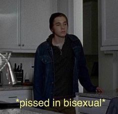 a man standing in a kitchen next to a sink with the caption pissed in bisexual