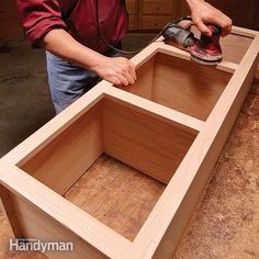 a man sanding down some wood with an electric sander on top of it