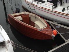 two boats are docked in the water next to each other, one is red and white