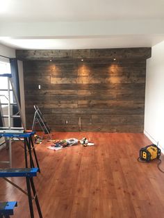 an empty room with hard wood flooring and construction tools on the ground in front of it