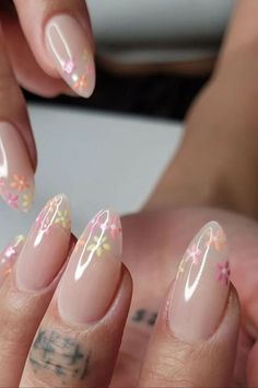 a woman's nails with flowers painted on them