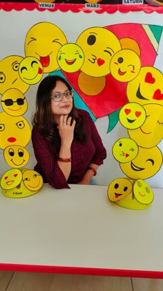 a woman sitting in front of a table with many yellow emoticions on it