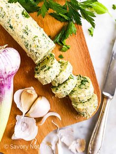 an assortment of food on a cutting board with garlic, parsley and other ingredients