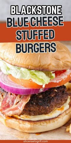 a hamburger with lettuce, tomato and cheese on it sitting on top of a wooden cutting board