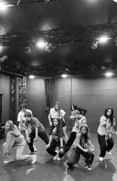 a group of young people standing on top of a dance floor in front of a stage