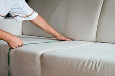 a man is working on the back of a couch that has been upholstered