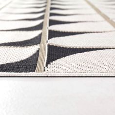 a black and white rug on the floor with an interesting design in the middle that looks like it has been made out of woven fabric