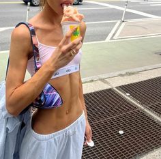 a woman eating an ice cream cone on the street