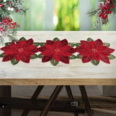 a christmas table runner with poinsettis on it