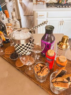 an assortment of snacks and condiments on a kitchen counter with bottles of alcohol