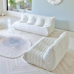 a living room with two white couches and a rug