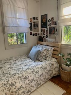 a bed sitting in a bedroom next to a window with pictures hanging on the wall