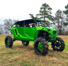 a green four - wheeled vehicle is parked in the grass