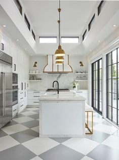 a kitchen with checkered flooring and an island in front of the stove top oven