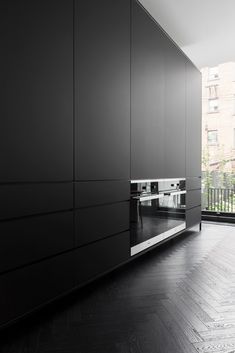 an empty kitchen with black cabinets and stainless steel stove top oven in the center of the room