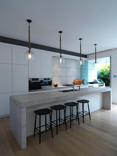 a kitchen with three stools next to an island