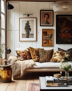 a living room filled with lots of furniture and pictures on the wall above it's windows