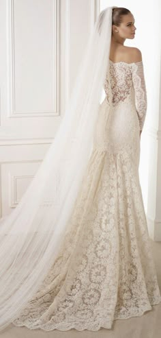 a wedding dress with an off the shoulder veil