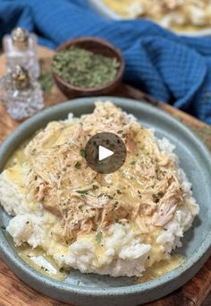 a plate with mashed potatoes covered in chicken and gravy