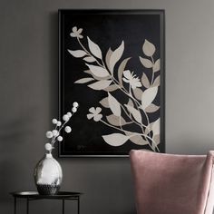 a black and white painting on the wall next to a pink chair in a living room