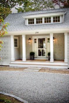 a small house with white trim and columns