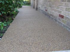 a walkway between two brick buildings next to plants