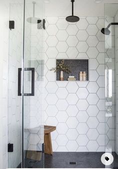 a white tiled bathroom with black and white accents