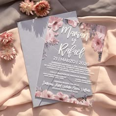 an image of a wedding card with flowers on the bed sheet next to it's wrap