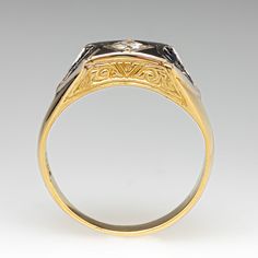 a gold and silver ring with an ornate design on the front, set in 18k yellow gold