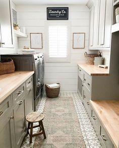 an instagram photo of a kitchen with white cabinets and gray appliances, along with a rug on the floor