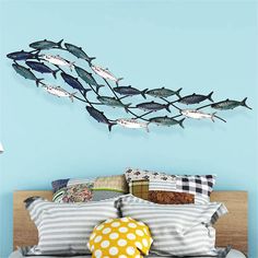 a bed room with a neatly made bed and a wall mounted fish sculpture on the wall