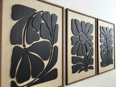 three black and white paintings hanging on the wall