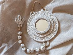 a mirror and necklace laying on a bed