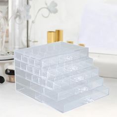 a stack of plastic drawers sitting on top of a white counter next to a mirror