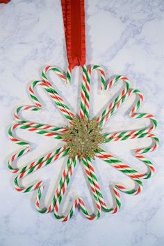 candy canes arranged in the shape of a snowflake on a marble surface