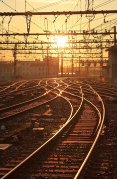 the sun is setting behind some train tracks