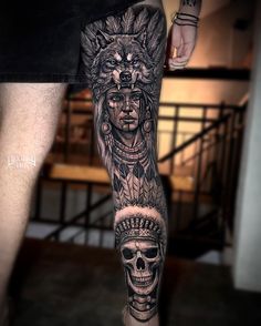 a man with a tattoo on his leg wearing a native american headdress and skull